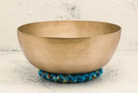 Close-up of a Tibetan singing bowl on a textured surface, embodying spiritual healing.