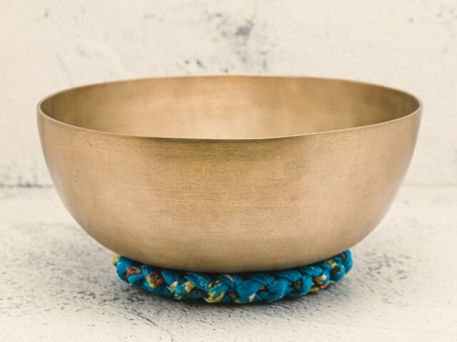 Close-up of a Tibetan singing bowl on a textured surface, embodying spiritual healing.